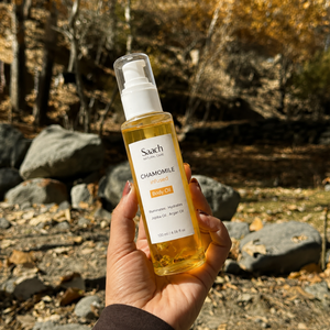 Saach chamomile infused body oil bottle with a floral label, showcasing the natural ingredient and elegant packaging.